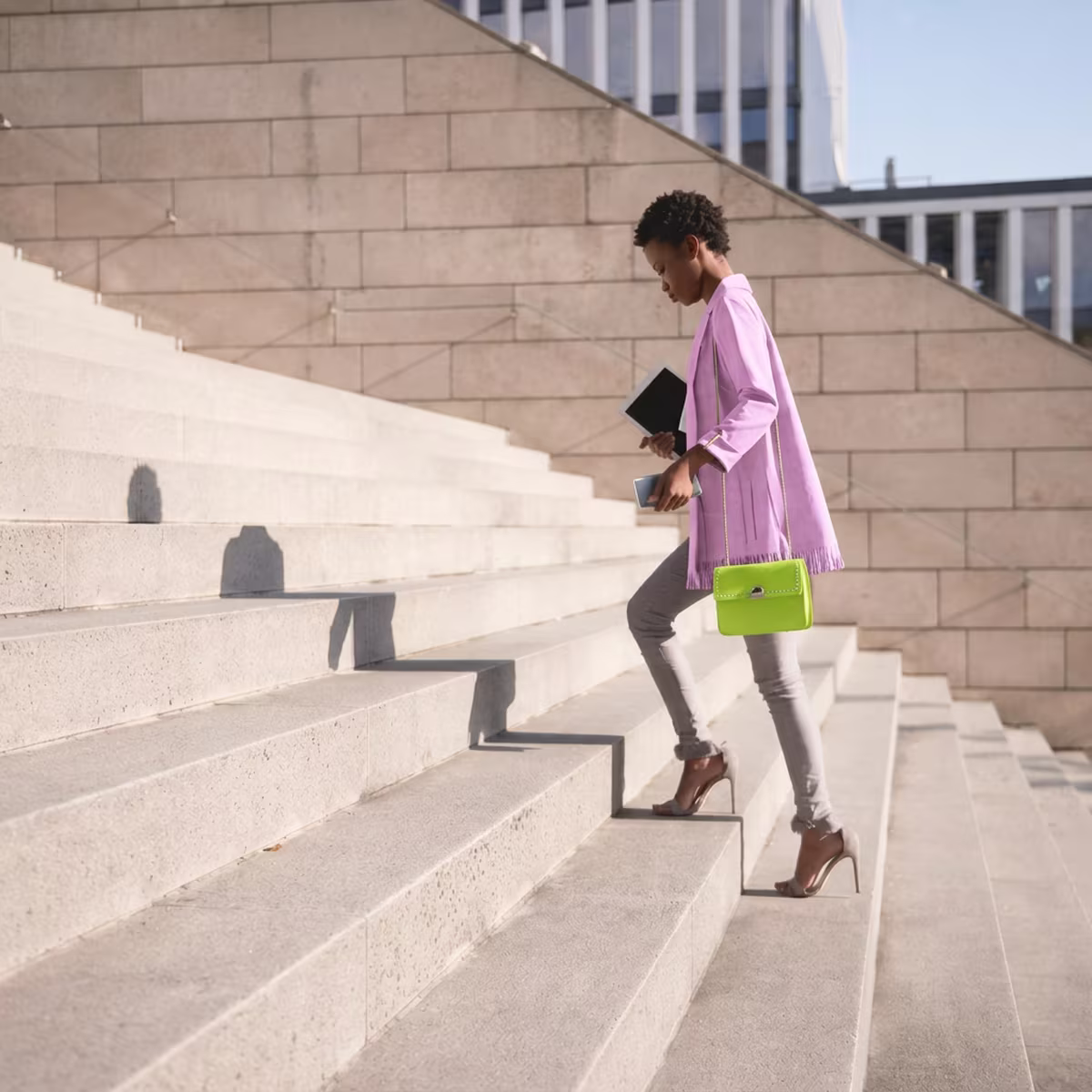 A student walking up the steps outside a university building, on her way to an interview.