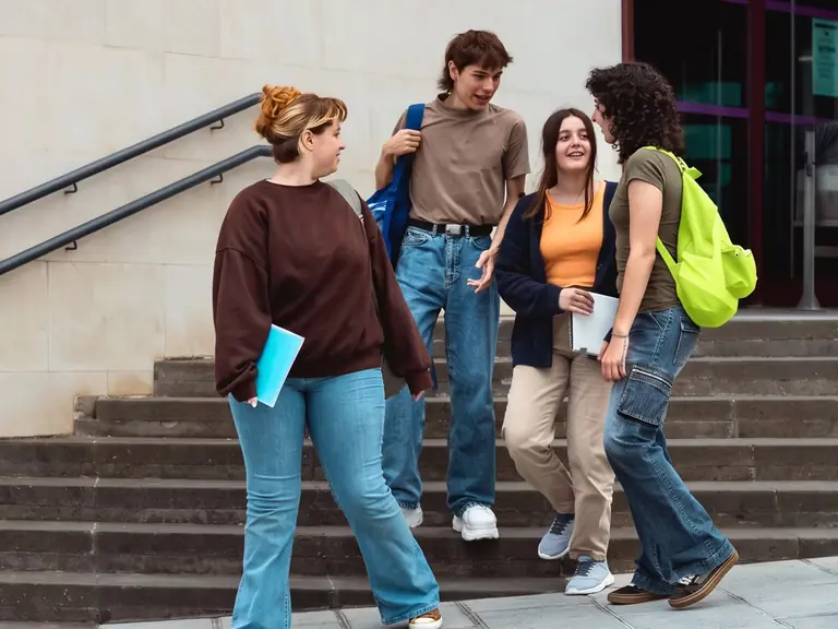 Four students talking on campus steps