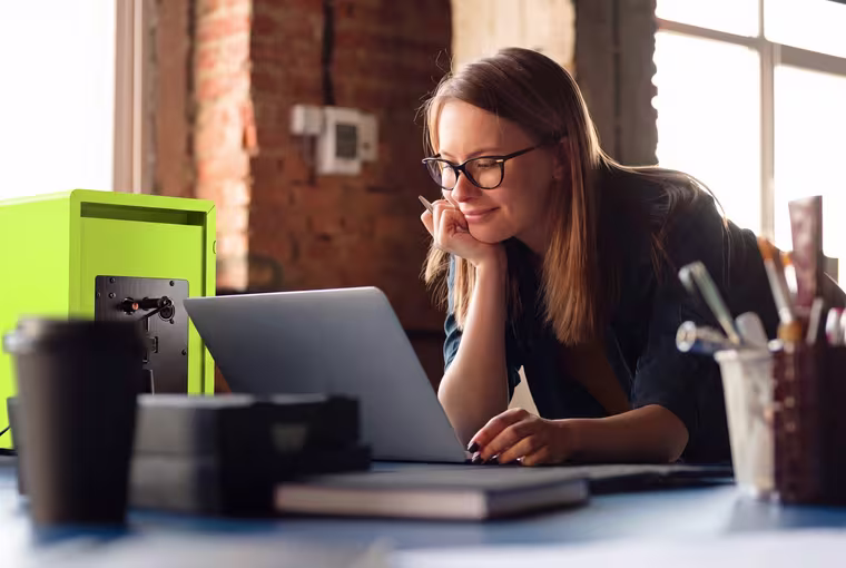 An academic planning a programme at her laptop.