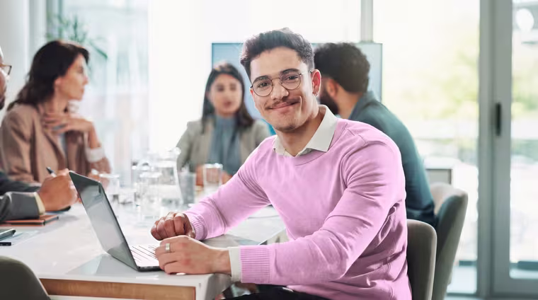 A programme participant at a cohort meeting table with colleagues.