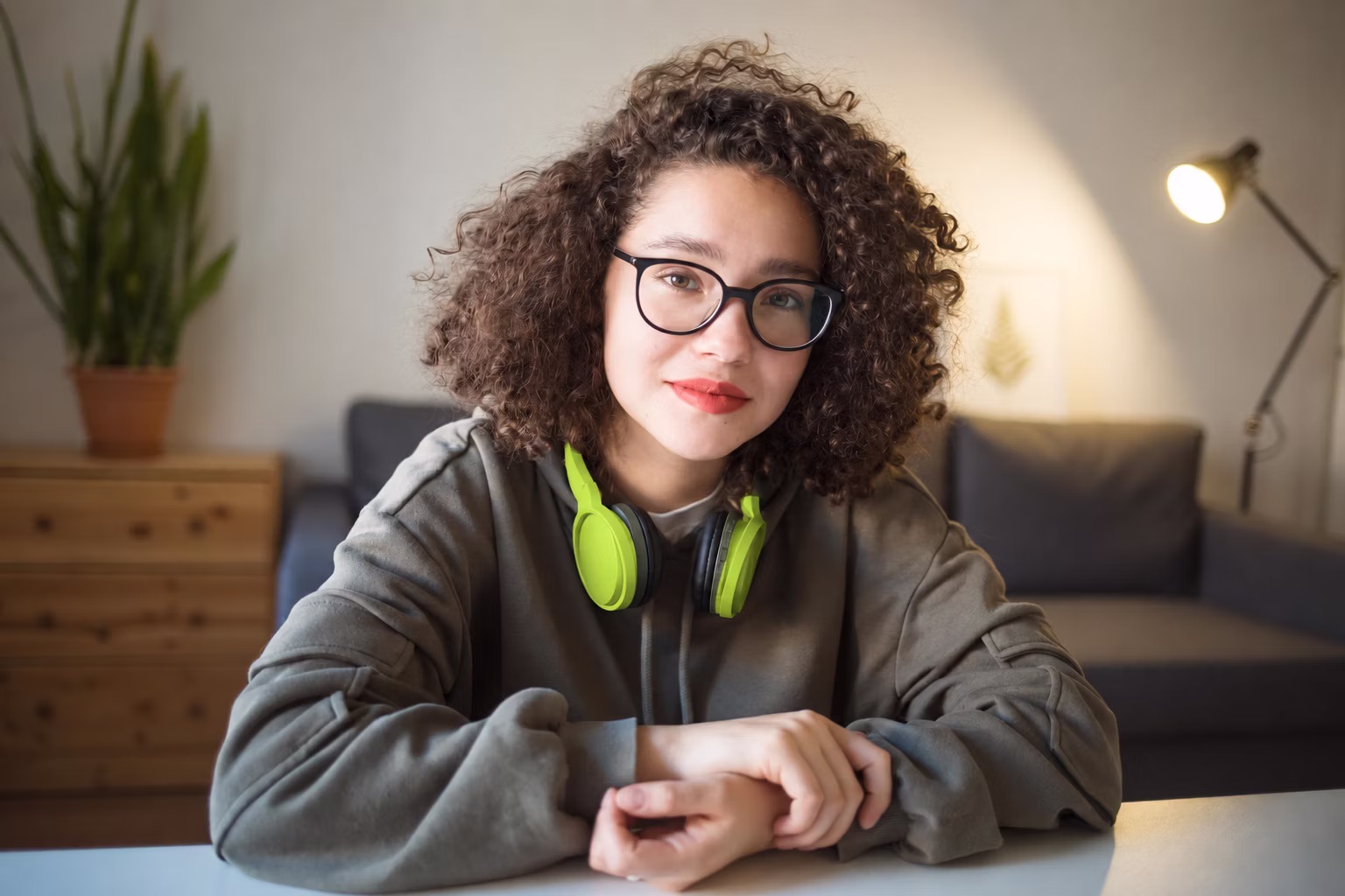 A first-year student at a desk with headphones round her neck.