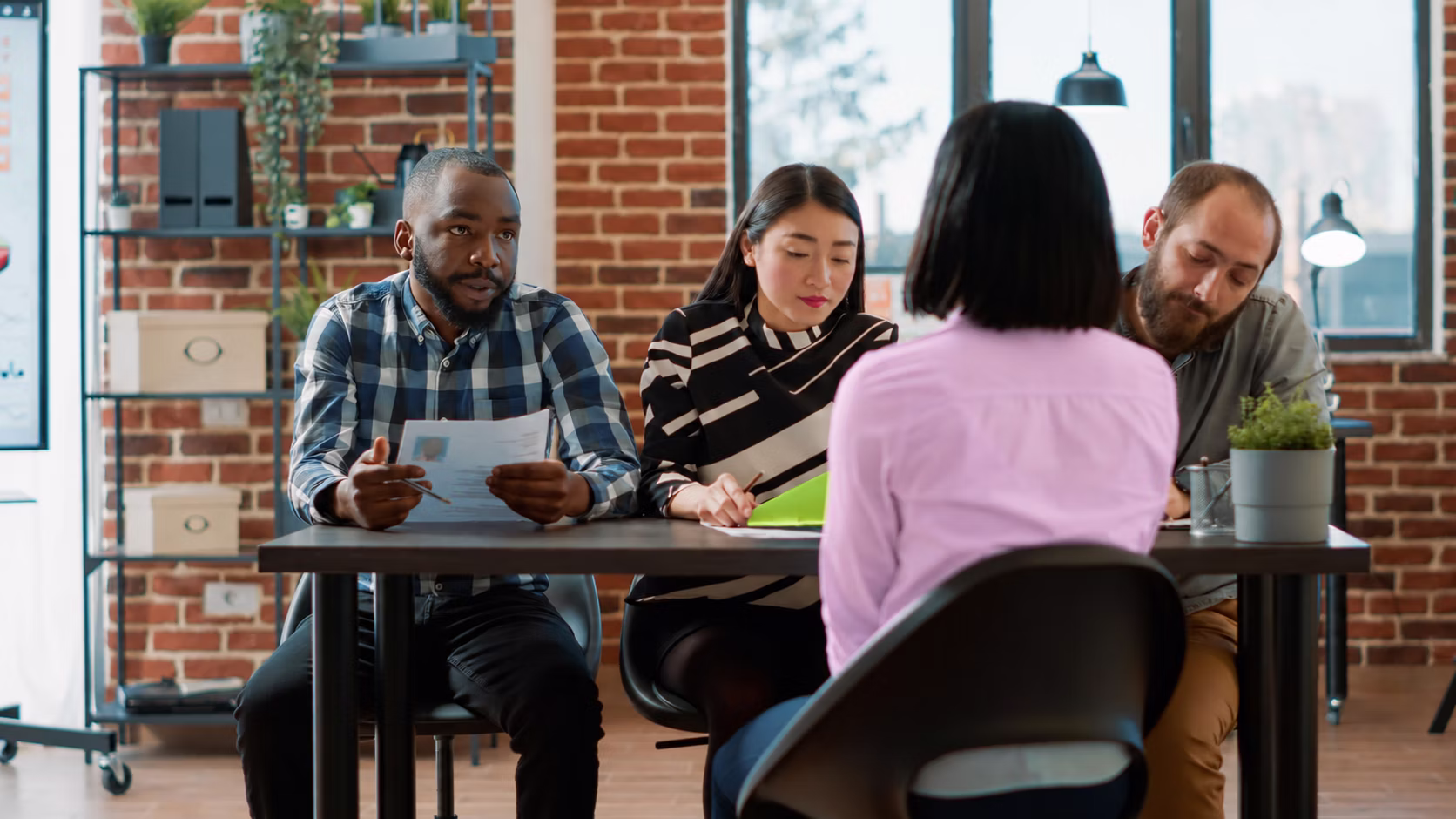 Students and staff talking around a table.