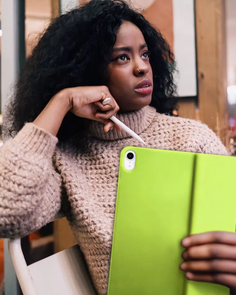 A student in a café with her tablet, working through the assessment.
