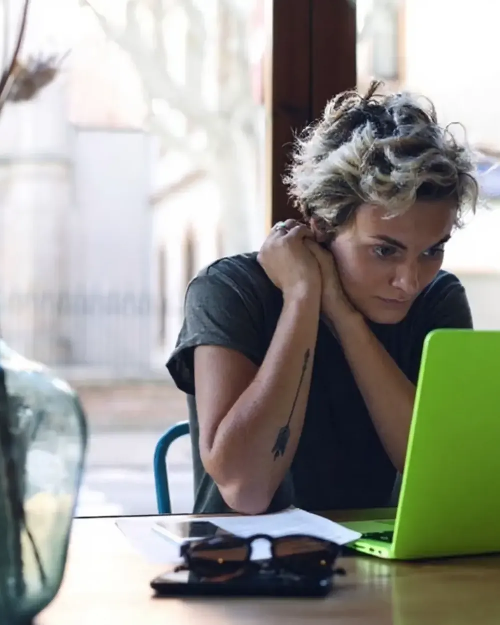 A student working through a problem at a laptop in a café.