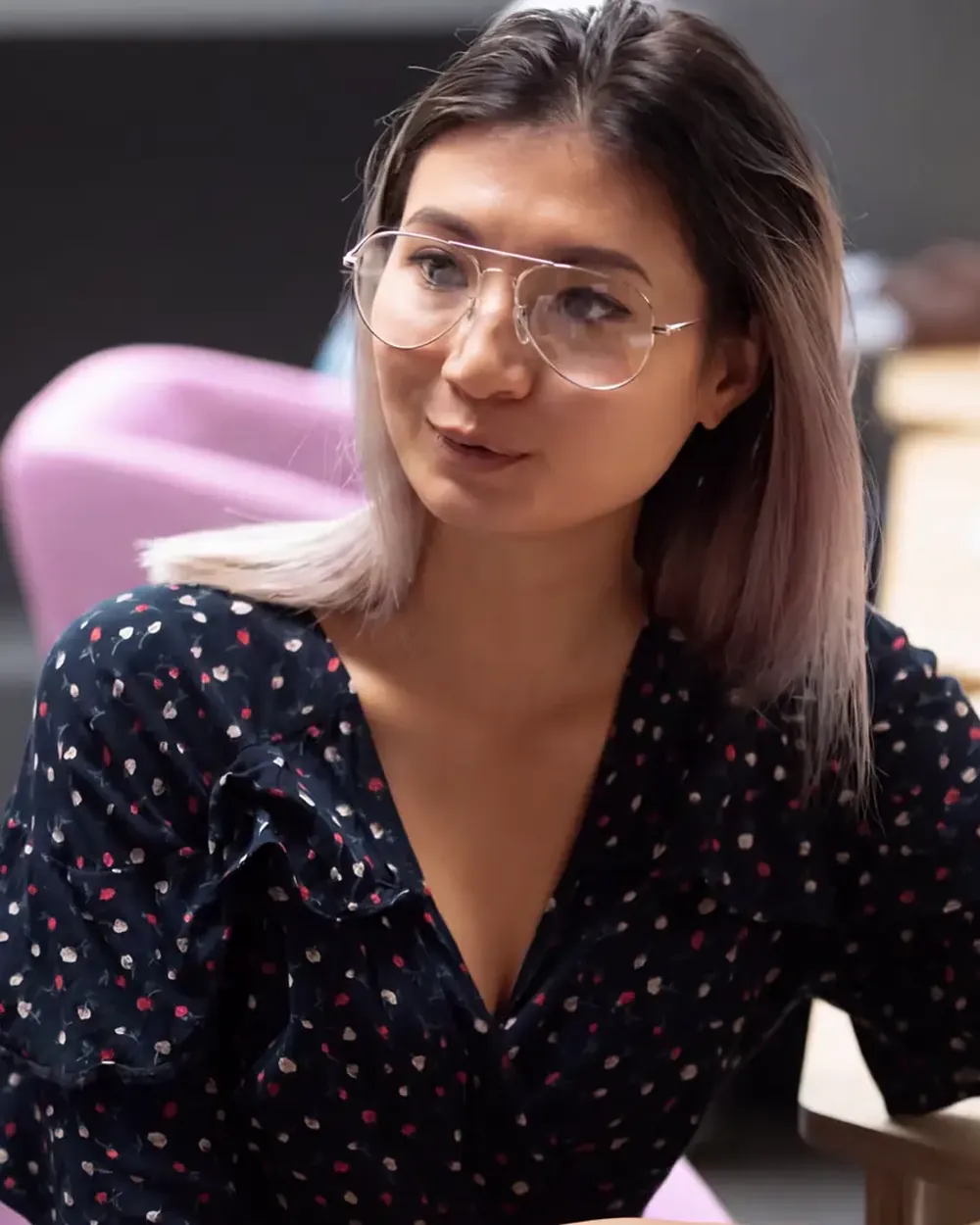 A student in conversation across a desk, listening.